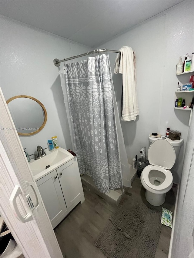 bathroom with hardwood / wood-style floors, vanity, toilet, and a shower with curtain