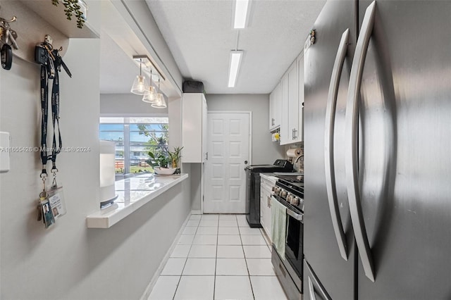 kitchen featuring stainless steel appliances, a textured ceiling, white cabinetry, and light tile patterned flooring