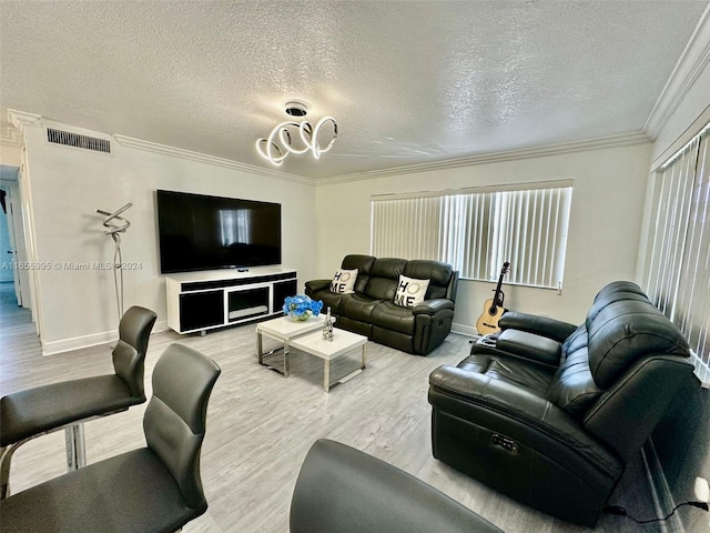 living room with ornamental molding, a textured ceiling, and light hardwood / wood-style floors