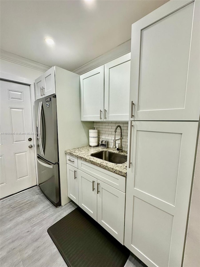 laundry room with light hardwood / wood-style flooring, cabinets, and sink