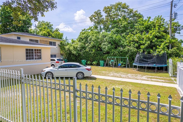 view of yard with a trampoline and a playground