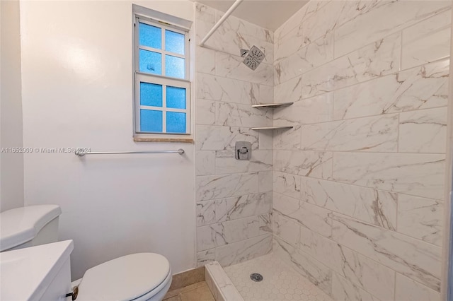 bathroom featuring tile patterned floors, tiled shower, toilet, and vanity