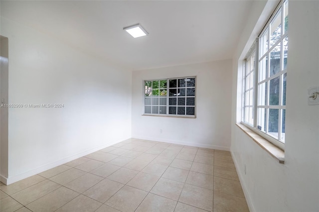 tiled empty room featuring a healthy amount of sunlight