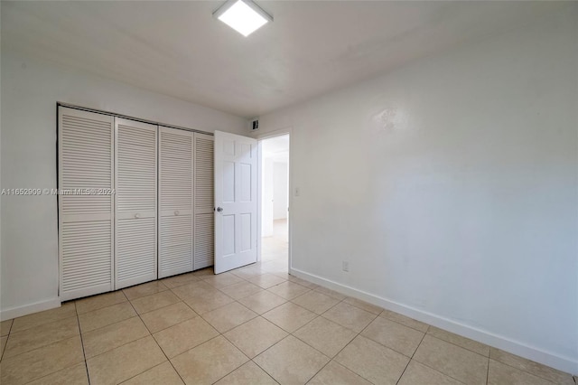 unfurnished bedroom featuring a closet and light tile patterned floors