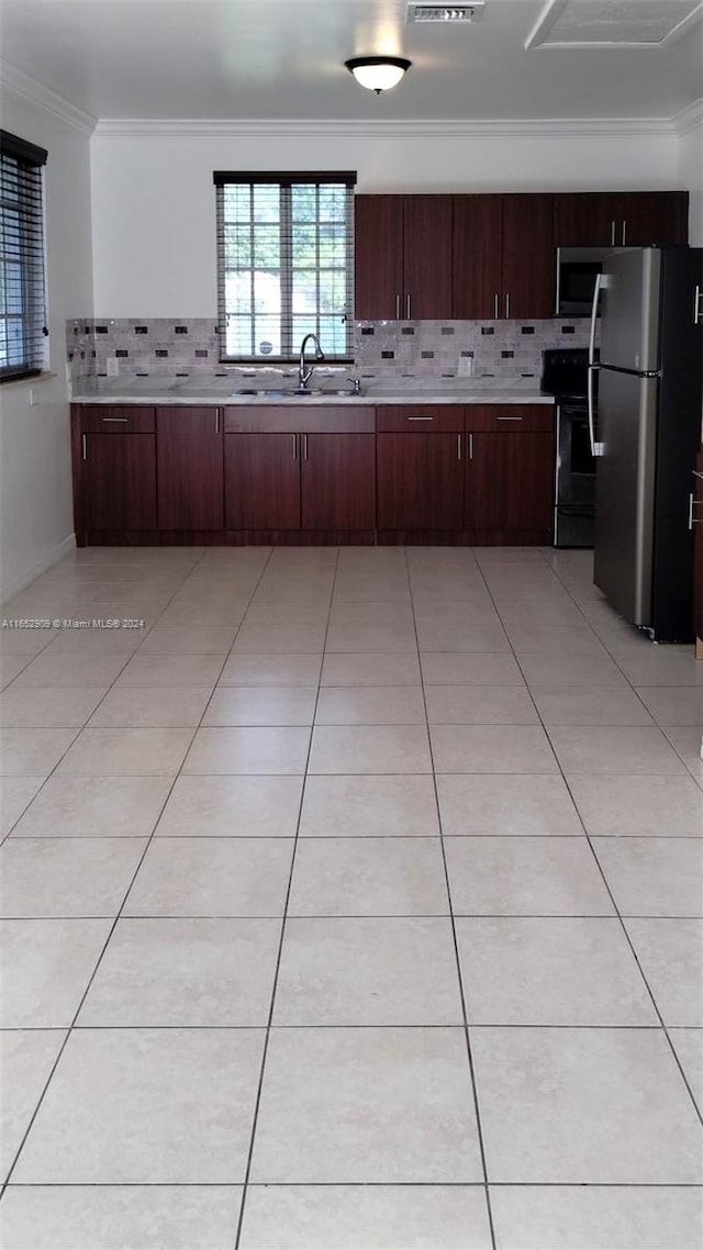 kitchen featuring crown molding, tasteful backsplash, light tile patterned floors, sink, and appliances with stainless steel finishes