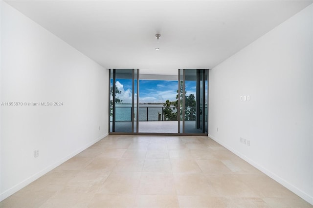 1135 103rd St Unit 202, Bay Harbor Islands, FL 33154 - empty room featuring floor to ceiling windows, a water view, and fire sprinkler in ceiling