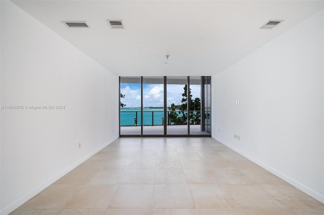 tiled empty room with floor to ceiling windows