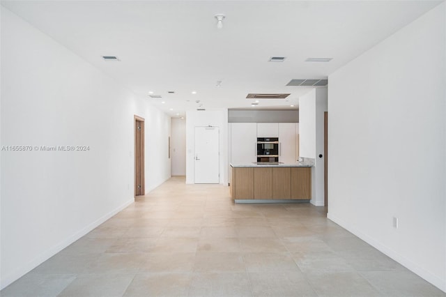 kitchen with double oven and white cabinetry