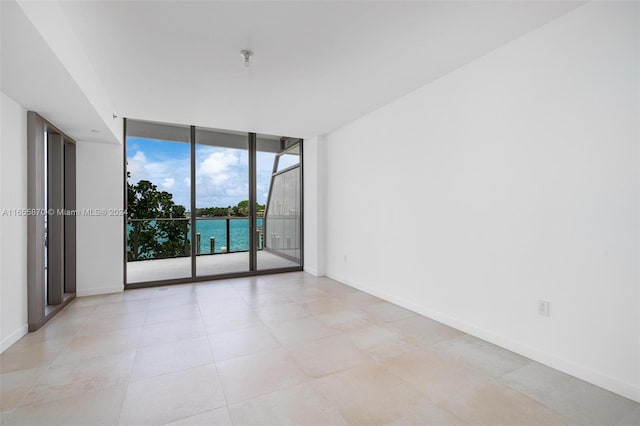 1135 103rd St Unit 202, Bay Harbor Islands, FL 33154 - empty room with floor to ceiling windows, light tile patterned floors, and a water view