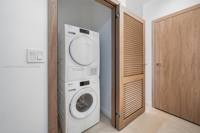 laundry area with stacked washer and clothes dryer and a barn door