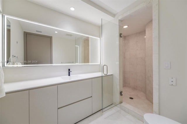 bathroom featuring vanity, toilet, and a shower with door