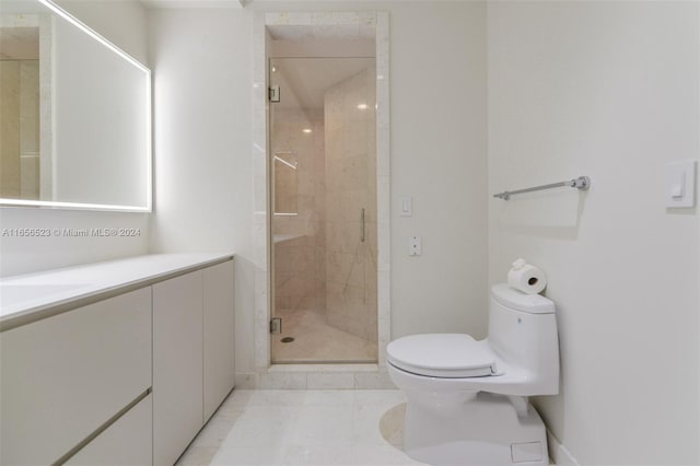 bathroom featuring vanity, toilet, a shower with shower door, and tile patterned floors