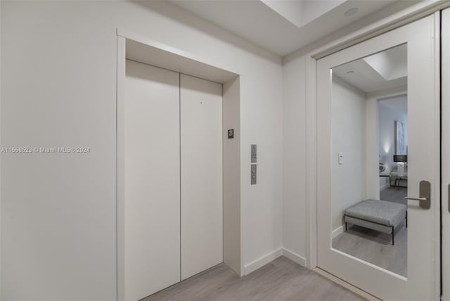 hall featuring elevator and light hardwood / wood-style flooring