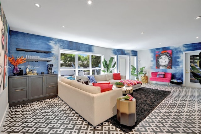 carpeted living room featuring bar area