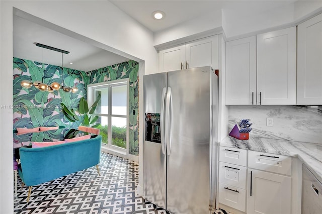 kitchen with dishwasher, stainless steel fridge, white cabinetry, and light stone countertops