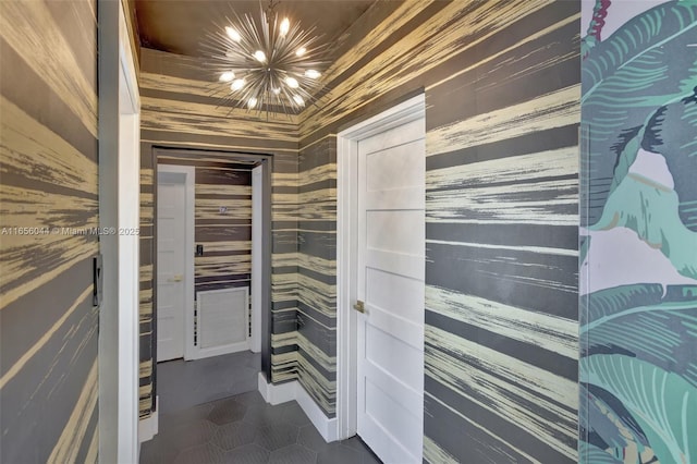 interior space featuring an inviting chandelier and dark tile patterned floors