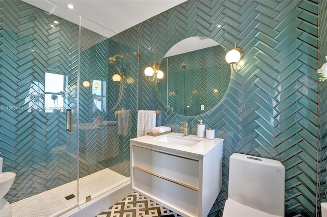 bathroom featuring vanity, toilet, tile walls, and a shower with shower door