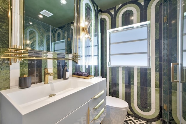 bathroom featuring vanity, toilet, plenty of natural light, and a shower with shower door