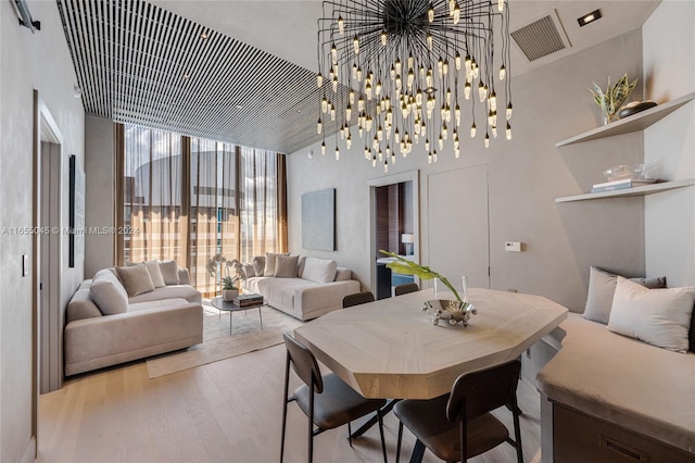 dining space featuring a high ceiling and light hardwood / wood-style flooring