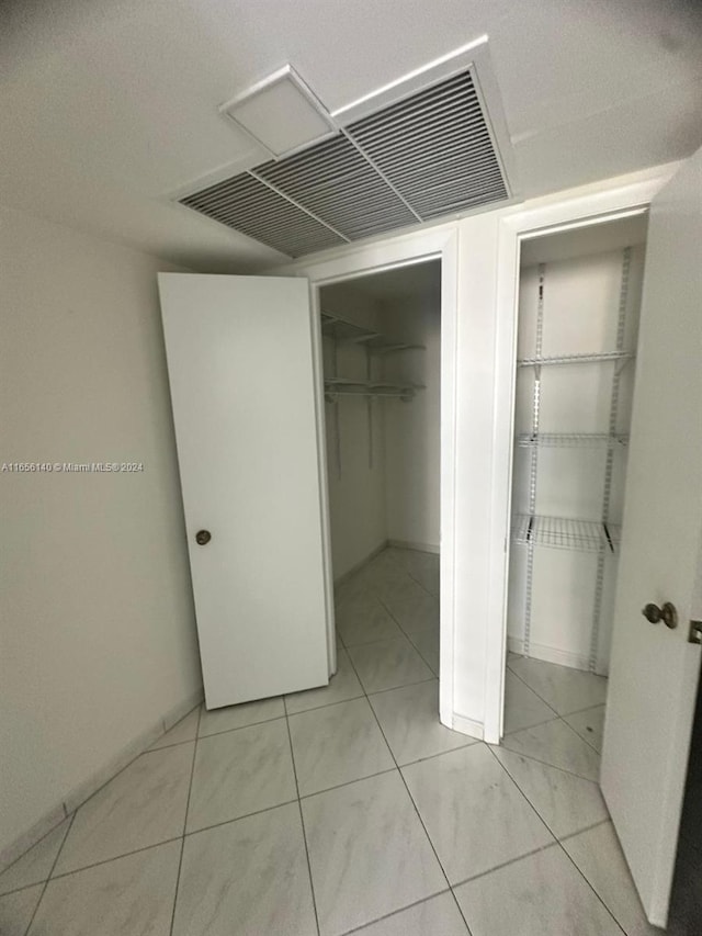 unfurnished bedroom featuring a closet and light tile patterned flooring