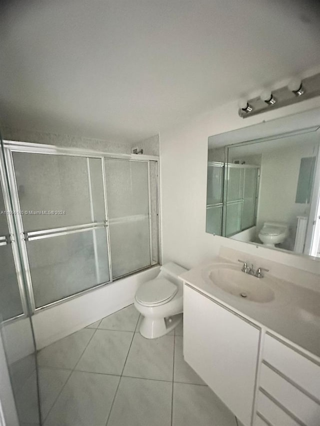 full bathroom featuring vanity, toilet, tile patterned floors, and bath / shower combo with glass door