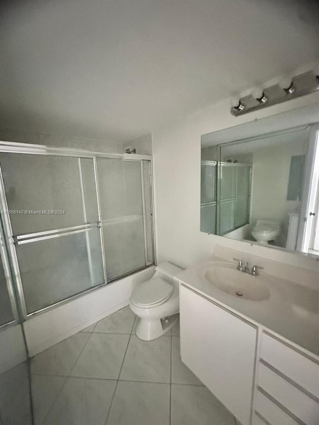 full bathroom with tile patterned floors, shower / bath combination with glass door, toilet, and vanity