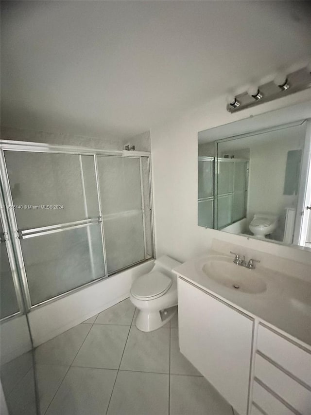 full bathroom with vanity, toilet, tile patterned flooring, and enclosed tub / shower combo