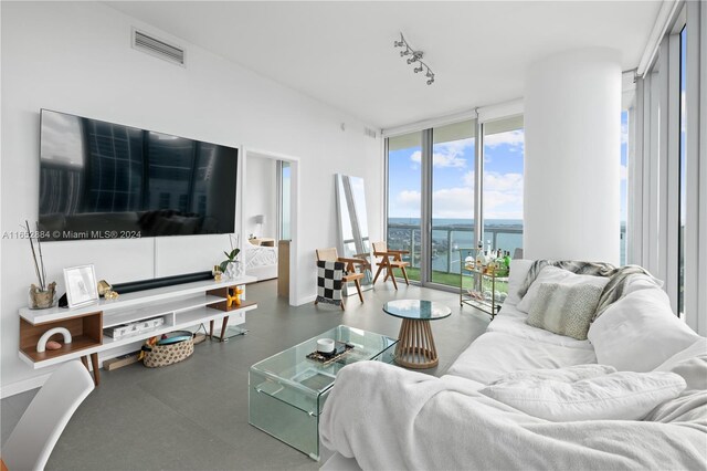 living room featuring a water view and a wall of windows