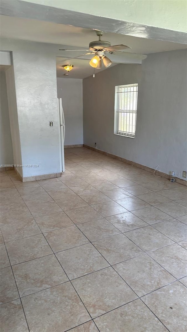 tiled empty room featuring lofted ceiling and ceiling fan