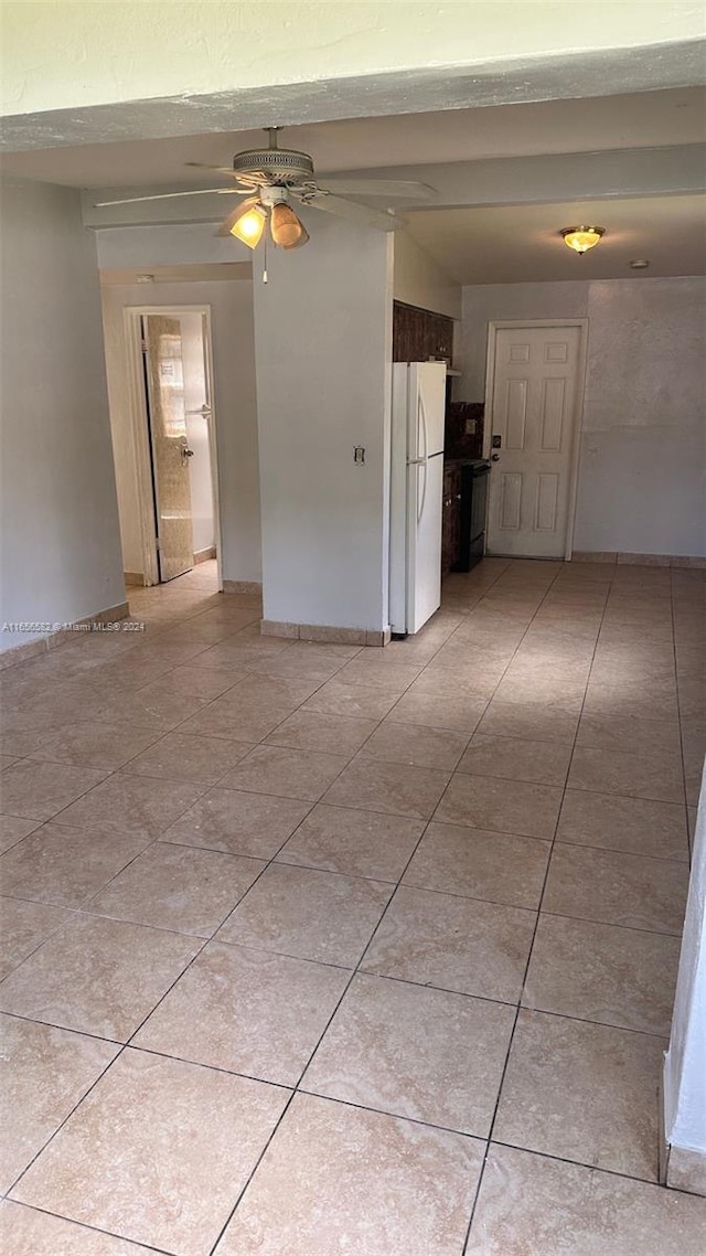 empty room with light tile patterned floors, baseboards, and a ceiling fan