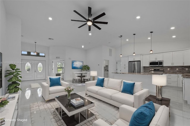 living room featuring ceiling fan and high vaulted ceiling