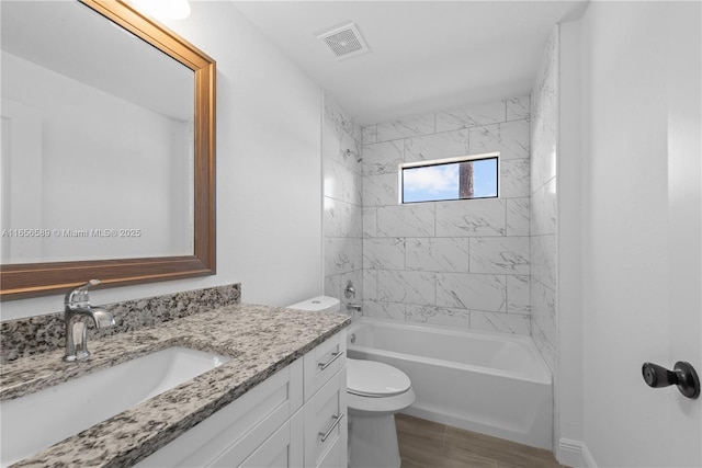 full bathroom with tiled shower / bath combo, vanity, and toilet