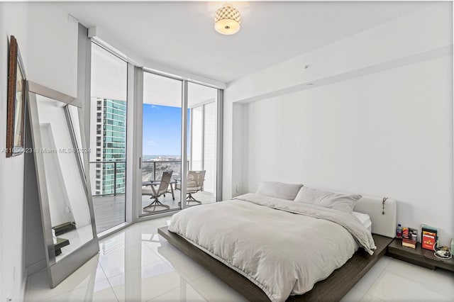 bedroom featuring light tile patterned floors, expansive windows, and access to outside