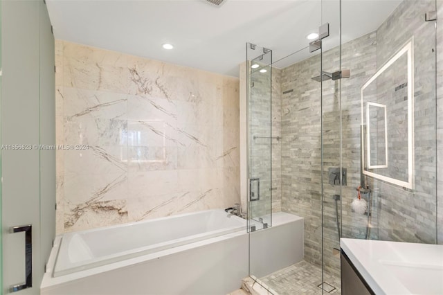 bathroom featuring vanity and independent shower and bath