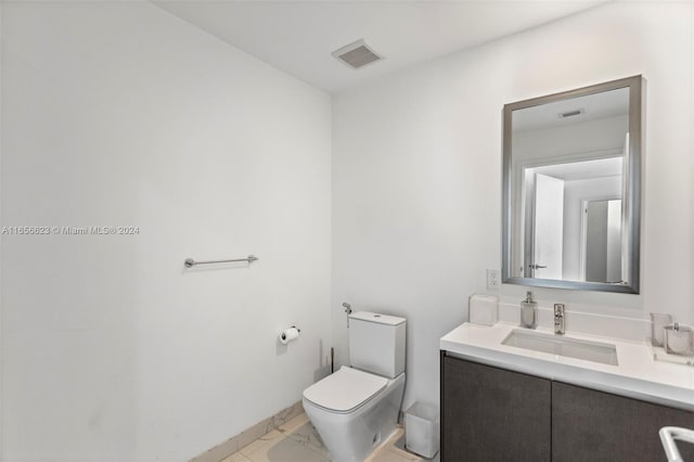 bathroom featuring tile patterned floors, toilet, and vanity