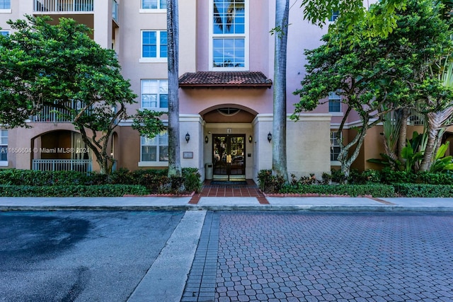 property entrance with a balcony and french doors