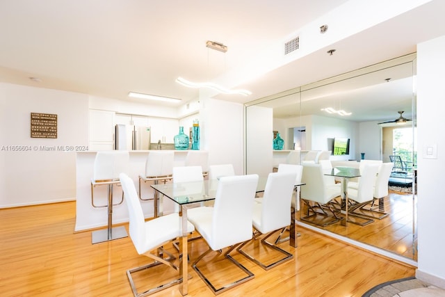 dining room with light wood-type flooring and ceiling fan