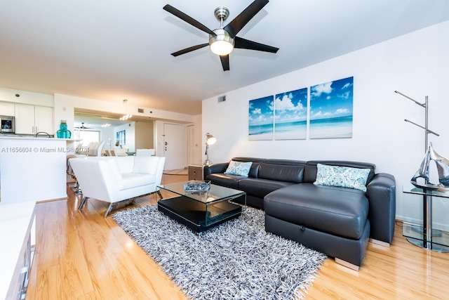 living room featuring light wood-type flooring and ceiling fan