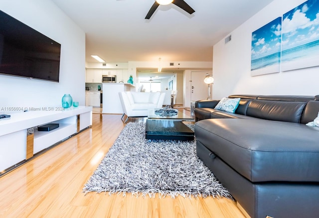 living room with ceiling fan and light wood-type flooring