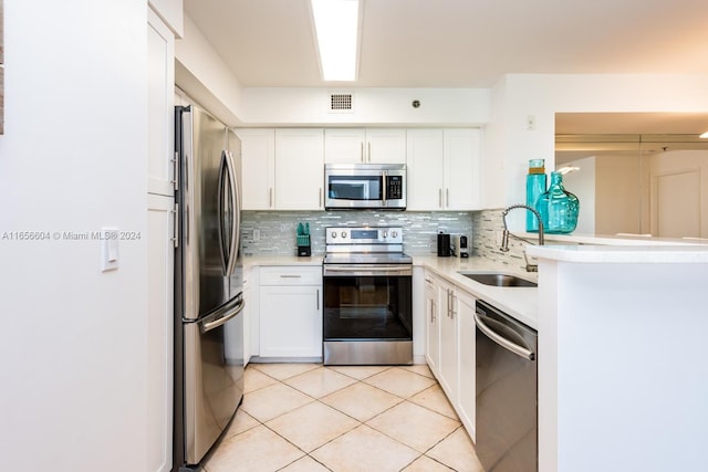 kitchen featuring backsplash, appliances with stainless steel finishes, sink, white cabinetry, and light tile patterned flooring