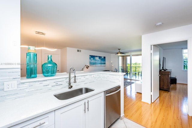 kitchen featuring pendant lighting, a wealth of natural light, stainless steel dishwasher, and sink