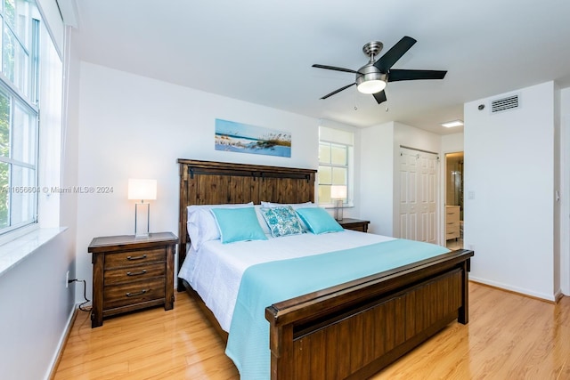 bedroom featuring ceiling fan, a closet, light wood-type flooring, and multiple windows