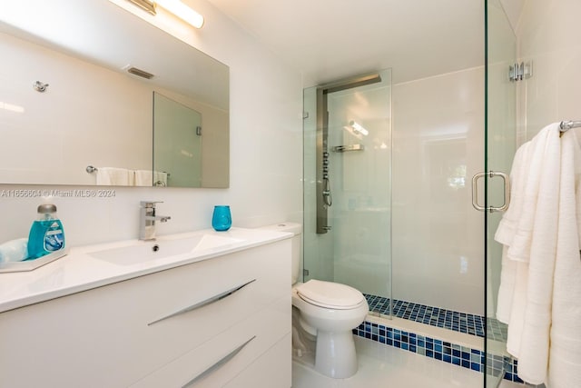 bathroom featuring vanity, toilet, and a shower with shower door