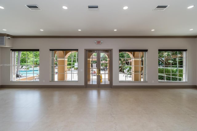 unfurnished living room featuring crown molding and a healthy amount of sunlight