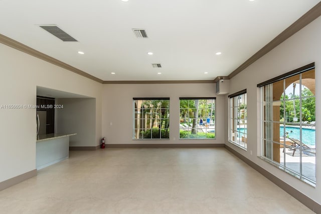 unfurnished living room with crown molding and a healthy amount of sunlight