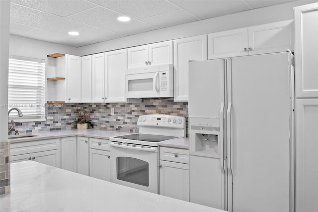 kitchen featuring white appliances, white cabinetry, and sink