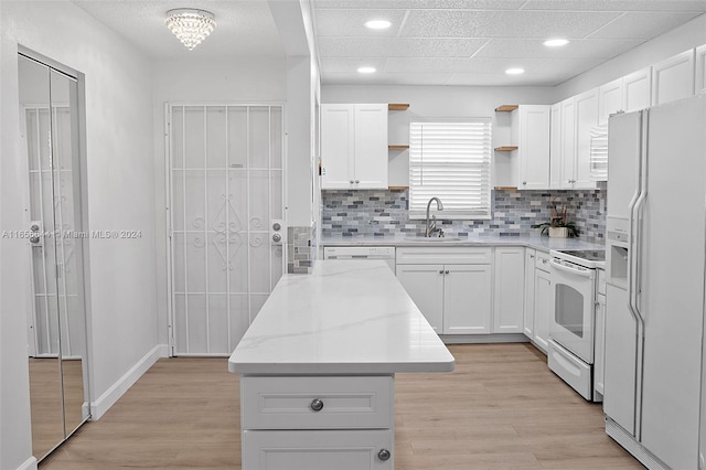 kitchen featuring light wood-type flooring, white appliances, sink, and white cabinets