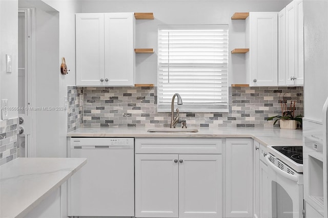 kitchen with white cabinetry, white appliances, backsplash, light stone counters, and sink