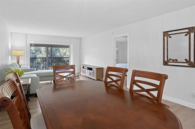 dining room with hardwood / wood-style flooring and a textured ceiling