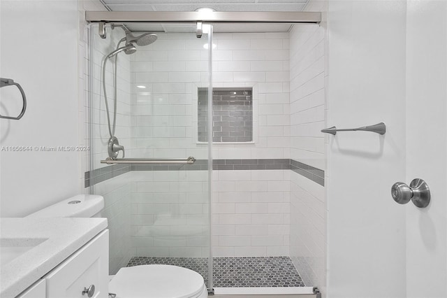 bathroom featuring toilet, a shower with door, and vanity